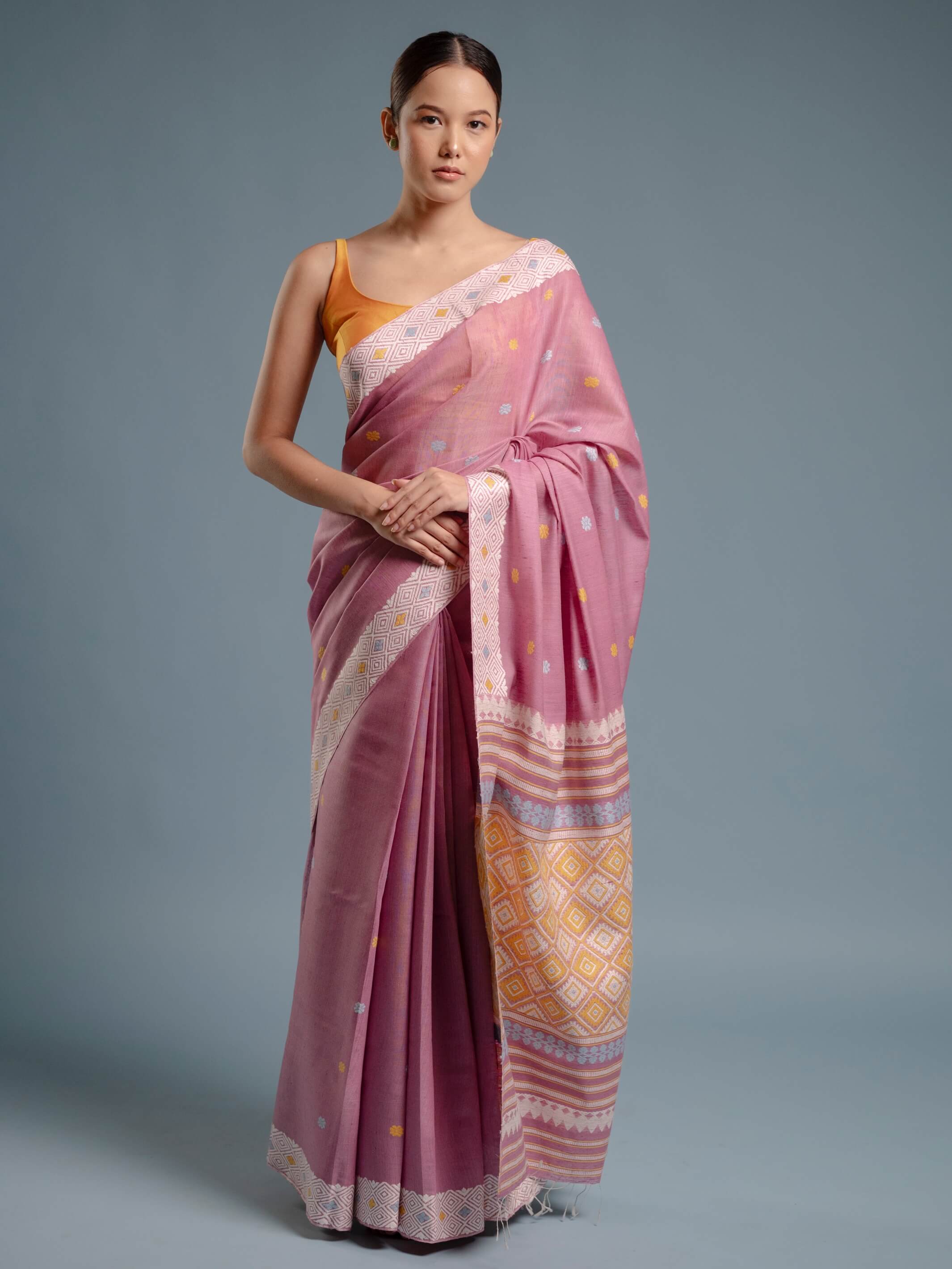 Woman wearing a lilac pink saree with a gray background