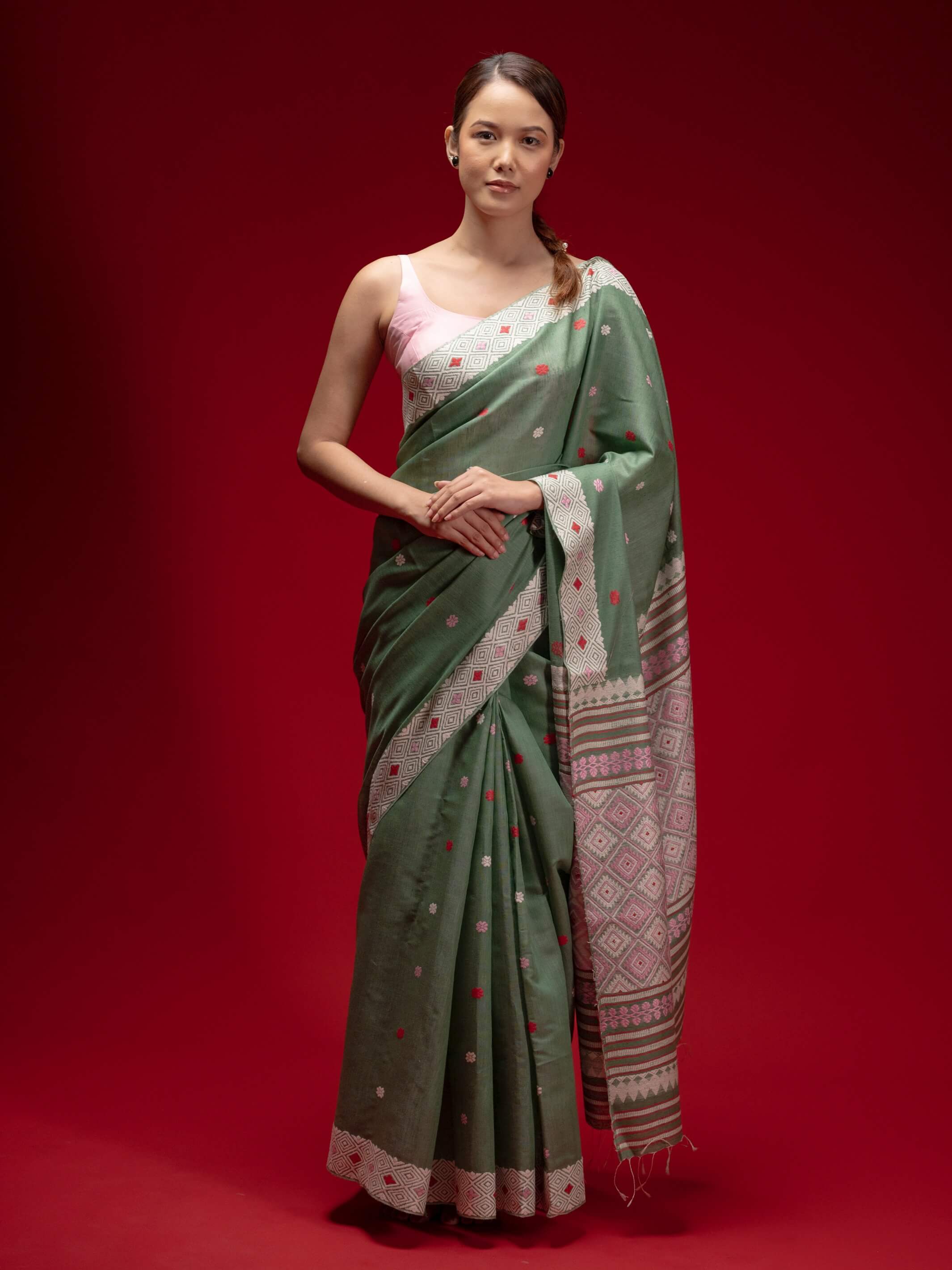 Woman wearing a green saree with a red  and pink motifs