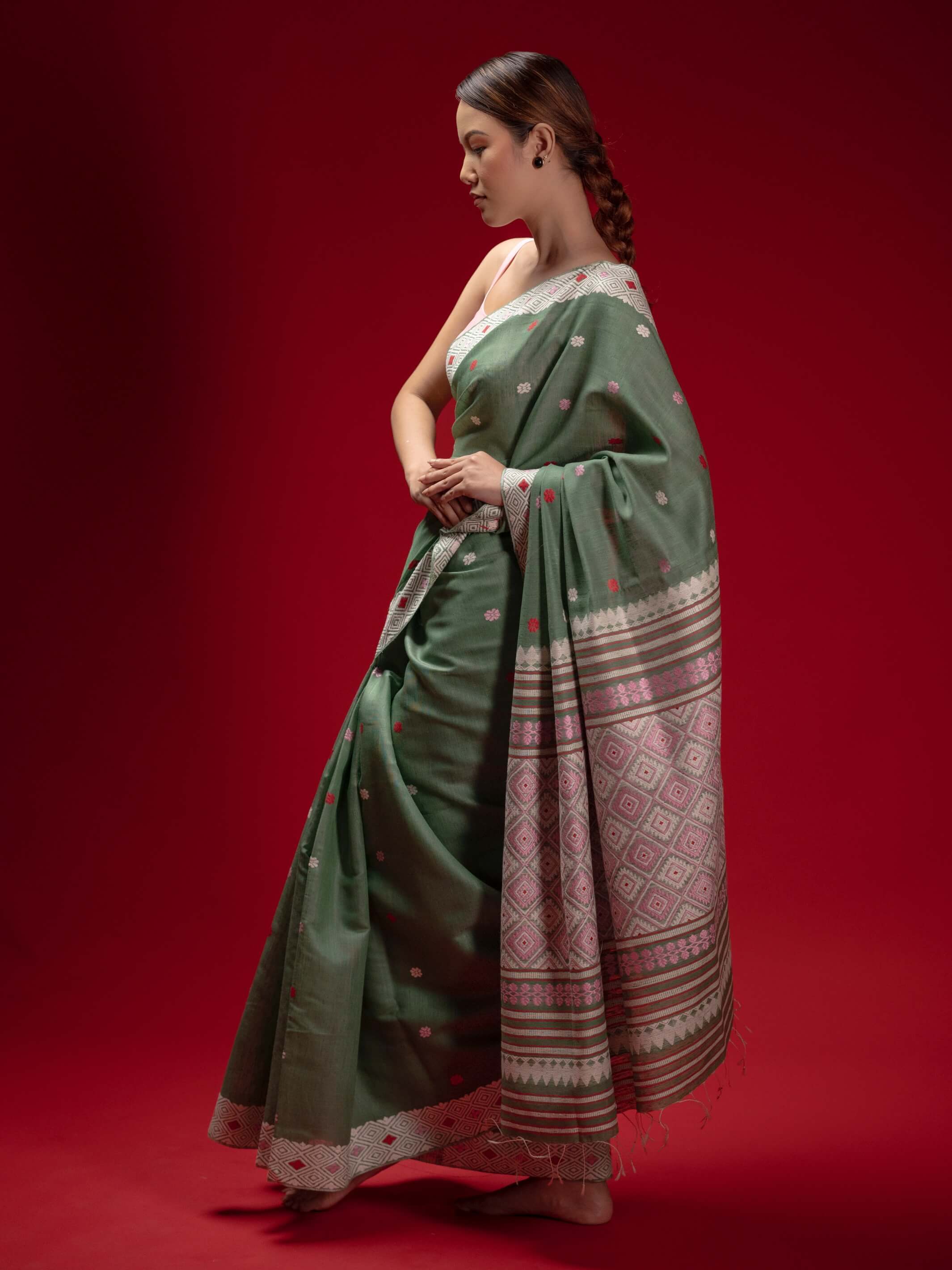 Woman wearing a green saree with a red  and pink motifs