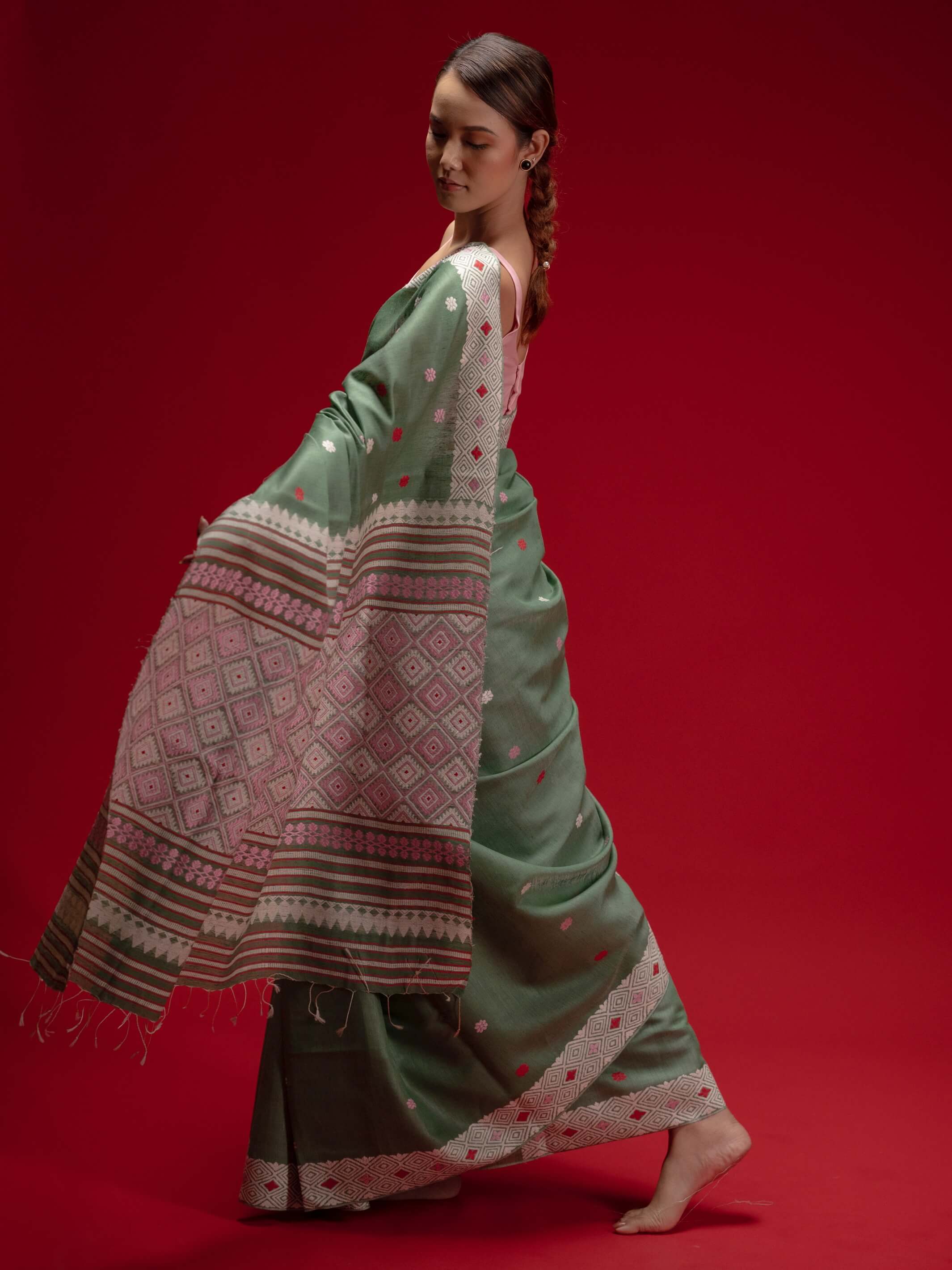 Woman wearing a green saree with a red  and pink motifs