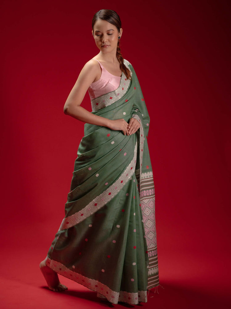 Woman wearing a green saree with a red  and pink motifs