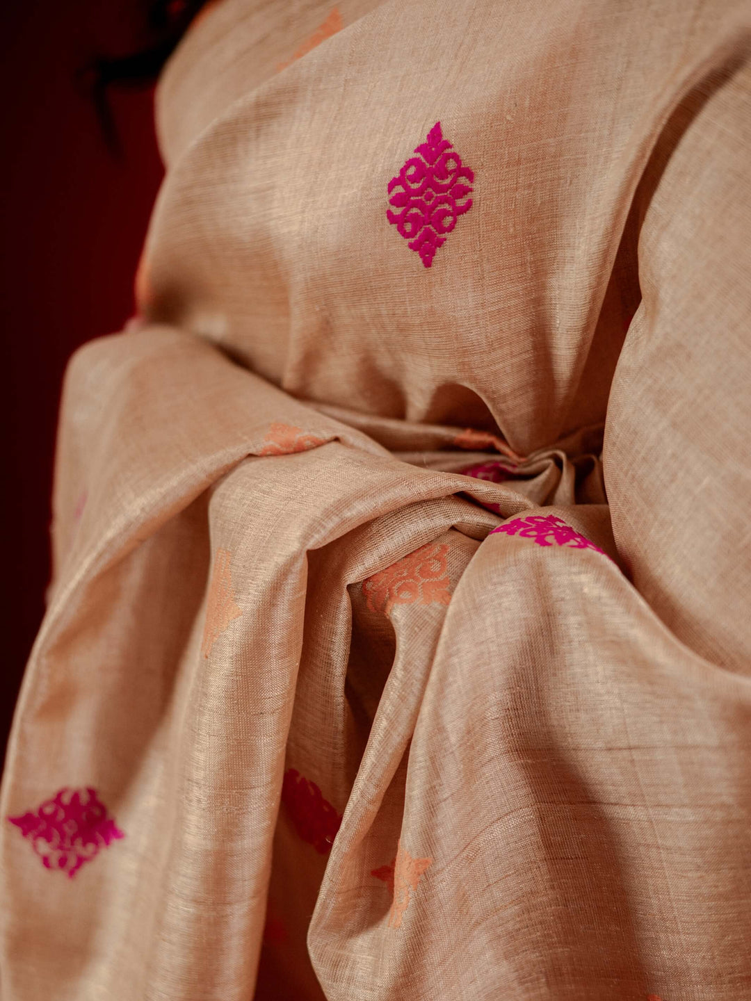 Muga fabric with pink floral patterns on a dark background