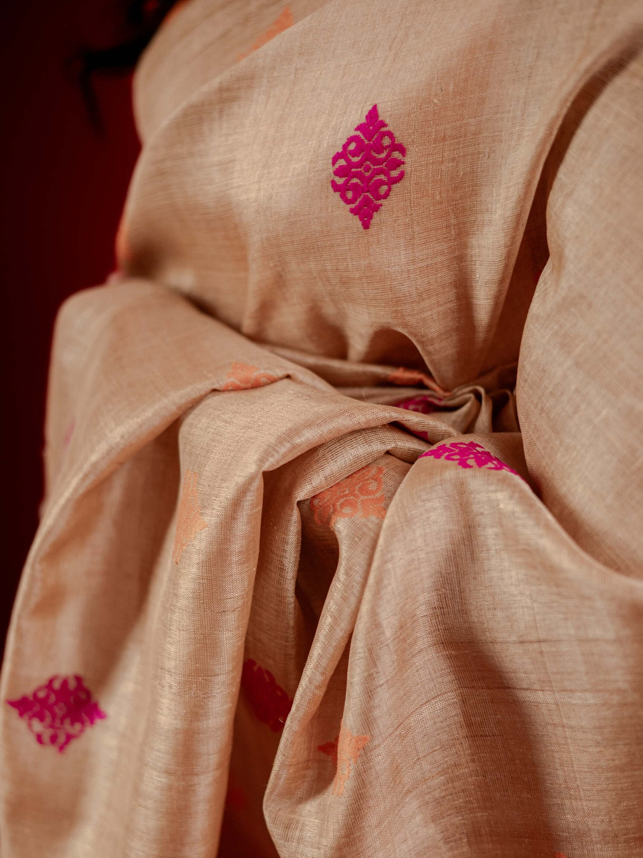 Muga fabric with pink floral patterns on a dark background